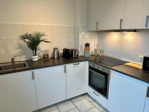 a kitchen with white cabinets and a stove top oven at ThreeRoom Gem of Essen in Essen