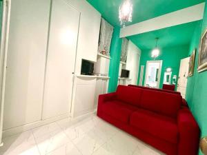 ein rotes Sofa im Wohnzimmer mit grünen Wänden in der Unterkunft Suite Oster Room - Ospedaletti in Ospedaletti