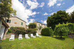 eine Gruppe weißer Stühle auf einem Hof in der Unterkunft Villa le Colline - Homelike Villas in Cingoli