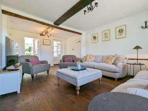 ein Wohnzimmer mit Sofas und einem Tisch in der Unterkunft Badgers Cottage 