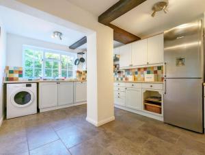 uma cozinha com um frigorífico e uma máquina de lavar louça em Badgers Cottage 
