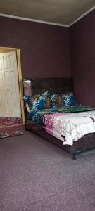 a bedroom with a bed with blue pillows at Penginapan Terdekat (Near) in Bukittinggi