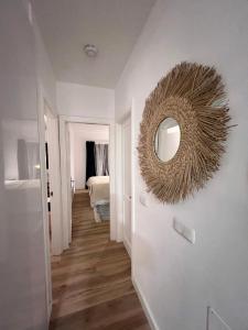 a hallway with a mirror and a bedroom with a bed at Bel Air surf escape in El Cotillo