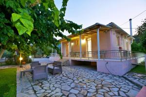 a house with a balcony and a patio at Drossos Garden House in Nydri