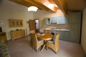 eine Küche mit einem Holztisch und Stühlen im Zimmer in der Unterkunft Villa le Colline - Homelike Villas in Cingoli