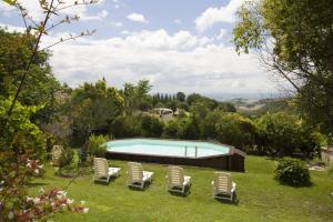 eine Gruppe von Liegestühlen und einem Pool in der Unterkunft Villa le Colline - Homelike Villas in Cingoli
