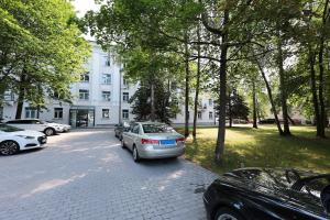 un estacionamiento con autos estacionados frente a un edificio en Mini dzīvoklis-atbilstoša cena, en Riga