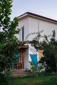 een wit huis met een blauwe paraplu ervoor bij Masal Evimiz in Antalya