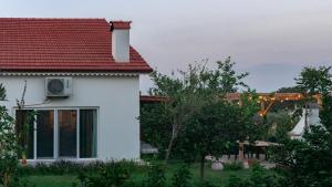 een wit huis met een rood dak bij Masal Evimiz in Antalya