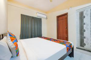 een slaapkamer met een wit bed en een raam bij FabHotel Valleyton Suites in Bangalore