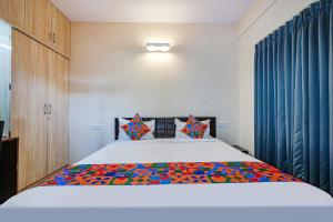 um quarto com uma cama com um cobertor colorido em FabHotel Valleyton Suites em Bangalore