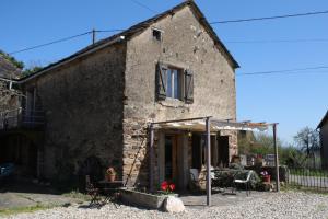 an old stone house with a patio in front of it at L'Oustal du Viaur - Gîtes Tournesol and Coquelicot in Pampelonne