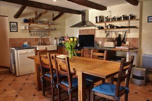 a kitchen with a wooden table and some chairs at L'Oustal du Viaur - Gîtes Tournesol and Coquelicot in Pampelonne