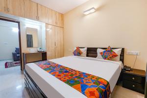 a bedroom with a large bed with a colorful blanket at FabHotel Crystal Suites - Near Marathahalli Junction in Bengaluru