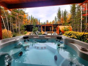 a hot tub in the backyard of a house at ONИEA l Sauna & Spa in Petite-Rivière-Saint-François