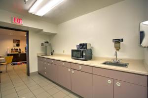 a kitchen with a counter with a microwave and a sink at Motel 6-Bozeman, MT in Bozeman