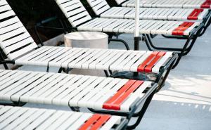 a row of white benches sitting on a sidewalk at El Rey Court in Santa Fe