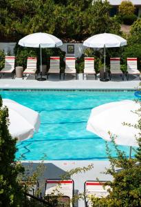 una piscina con sillas y sombrillas en El Rey Court, en Santa Fe