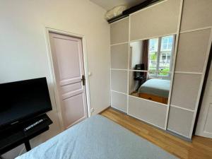 ein Schlafzimmer mit einem Bett und einem großen Spiegel in der Unterkunft L'interlude in Chaville