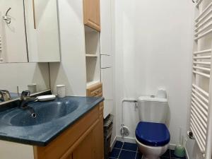 ein Badezimmer mit einem blauen WC und einem Waschbecken in der Unterkunft L'interlude in Chaville