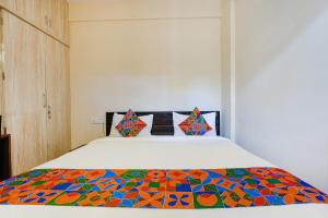 a bedroom with a bed with a colorful comforter at FabHotel Crystal Suites - Near Marathahalli Junction in Bengaluru