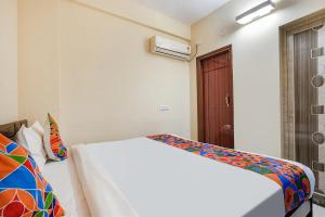 a bedroom with a white bed and a wooden door at FabHotel Crystal Suites - Near Marathahalli Junction in Bengaluru +27 photos