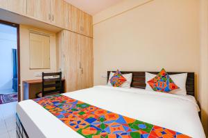 a bedroom with a bed with a colorful blanket on it at FabHotel Crystal Suites - Near Marathahalli Junction in Bengaluru