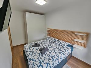 a small bedroom with a bed with a wooden headboard at Family apartment Besos 2 in Barcelona
