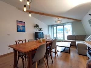 L'AQUAE - Parking - Wifi - Netflix في إيكس لي بان: غرفة طعام وغرفة معيشة مع طاولة وكراسي خشبية