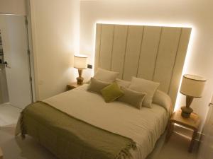 1 dormitorio con 1 cama grande y 2 lámparas en Precioso apartamento nuevo en calle Ferraz, en Madrid