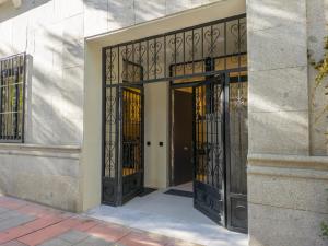 una entrada a un edificio con puertas de hierro forjado en Precioso apartamento nuevo en calle Ferraz, en Madrid