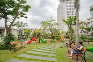Ludzie siedzący na ławkach w parku w obiekcie Kim's Apartment - 800m to Marina Beach - Full kitchen, Washing Machine w Ha Long
