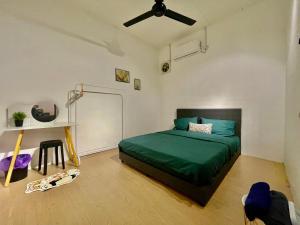 a bedroom with a green bed and a ceiling fan at Home41#4pax#Netflix#NearAeonAlma#BM#5kmtoIconicPoint in Bukit Mertajam