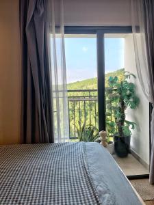 sypialnia z łóżkiem i dużym oknem w obiekcie Kim's Apartment - 800m to Marina Beach - Full kitchen, Washing Machine w Ha Long