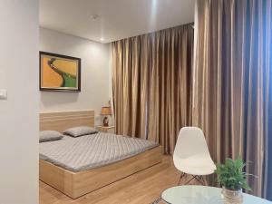 sypialnia z łóżkiem i białym krzesłem w obiekcie Kim's Apartment - 800m to Marina Beach - Full kitchen, Washing Machine w Ha Long
