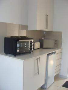 une cuisine avec un four micro-ondes noir sur un comptoir dans l'établissement Lonehill - Standard 2 Guest Suite - Suite 1B, à Sandton