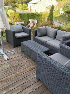 a patio with wicker chairs and couches on a deck at B&B Oase in Braunlauf