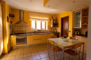a kitchen with yellow walls and a table and chairs at V PRINCESA vivienda con piscina climatizada y bbq in Puerto del Carmen