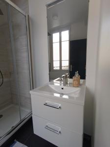 a white bathroom with a sink and a shower at Résidence Les Bénédictins in Limoges