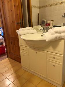 a bathroom with a sink and a mirror and towels at Stanza privata a 10 minuti dall'Abetone in Pian di Novello