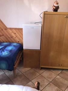 a small refrigerator next to a bed in a room at Stanza privata a 10 minuti dall'Abetone in Pian di Novello