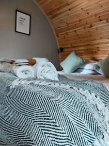 a bedroom with a bed with towels on it at Eastfield Glamping Farm in Spennithorne