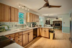 cocina con armarios de madera y ventilador de techo en The Compass Rose by Leavetown Vacations en Annapolis