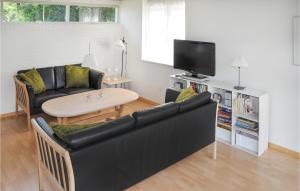 sala de estar con sofá negro y mesa en 3 Bedroom Cozy Home In Sydals, en Skovby