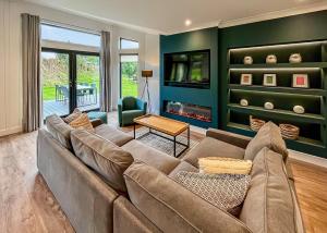 ein Wohnzimmer mit einem großen Sofa und einem Kamin in der Unterkunft Forest Hills Lodges in Coleford