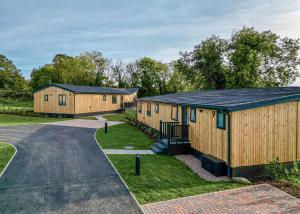 eine Reihe von Holzgebäuden auf einer Straße in der Unterkunft Forest Hills Lodges in Coleford