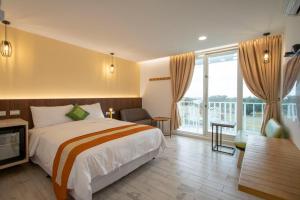 a hotel room with a bed and a balcony at Kenting Shin Yu Homestay in Kenting