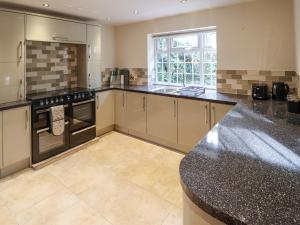 a large kitchen with black counter tops and appliances at Woodland Lodge in Boston