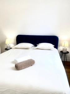 1 cama blanca grande con 2 almohadas y 2 lámparas en *Chic & Basic T3* place Carnot, en Carcassonne