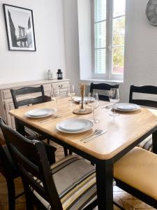 una mesa de madera con vasos y platos. en *Chic & Basic T3* place Carnot, en Carcassonne